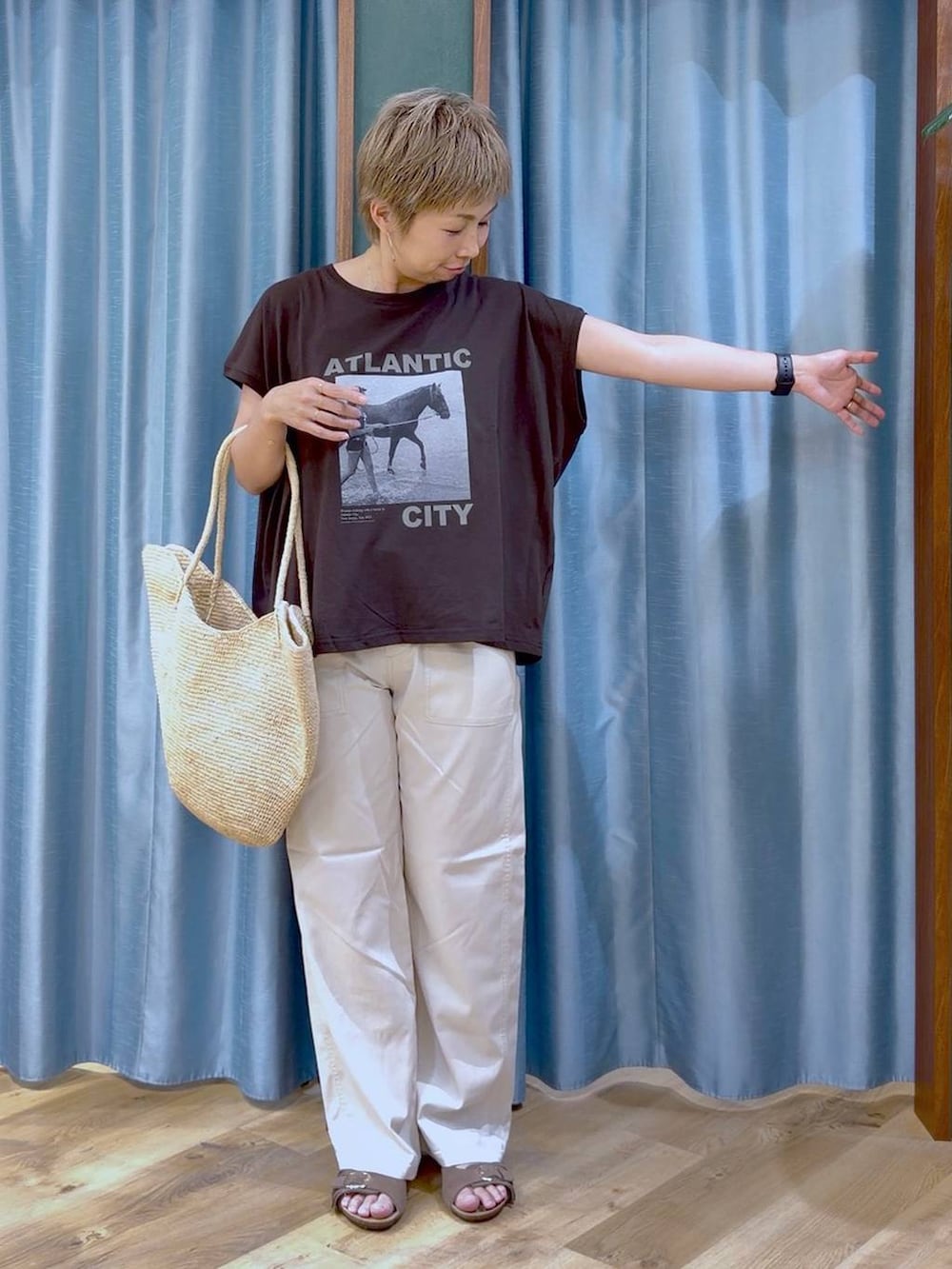 ブラウン系のTシャツ/カットソー、ホワイト系のチノパンツ、ブラウン系のサンダルを着用したレディースの夏コーディネートの5枚目の写真