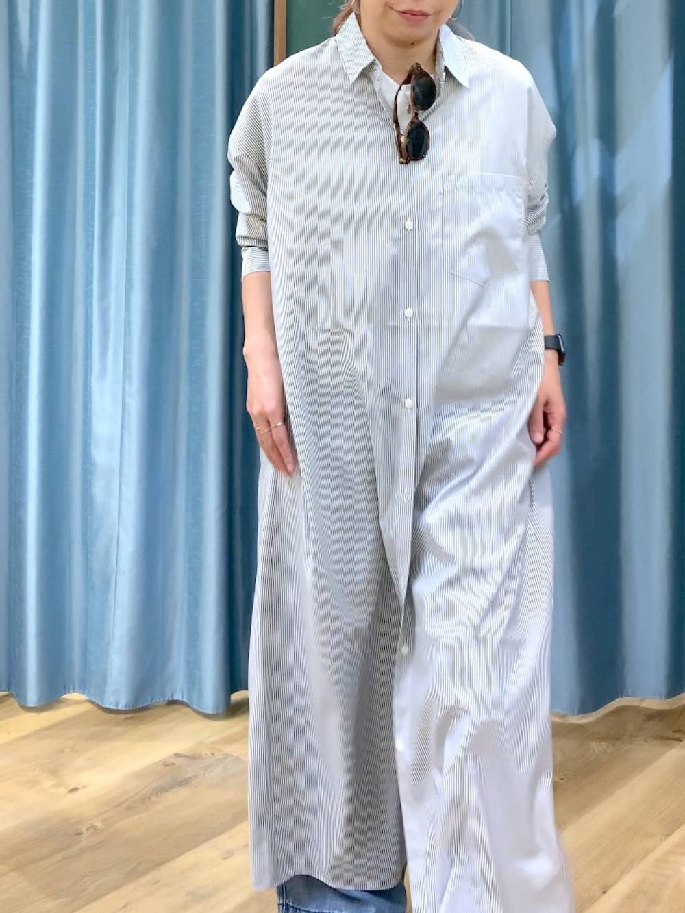 ブラック系のワンピース、ブルー系のデニムパンツ、ブラック系のサンダルを着用したレディースの春コーディネートの6枚目の写真