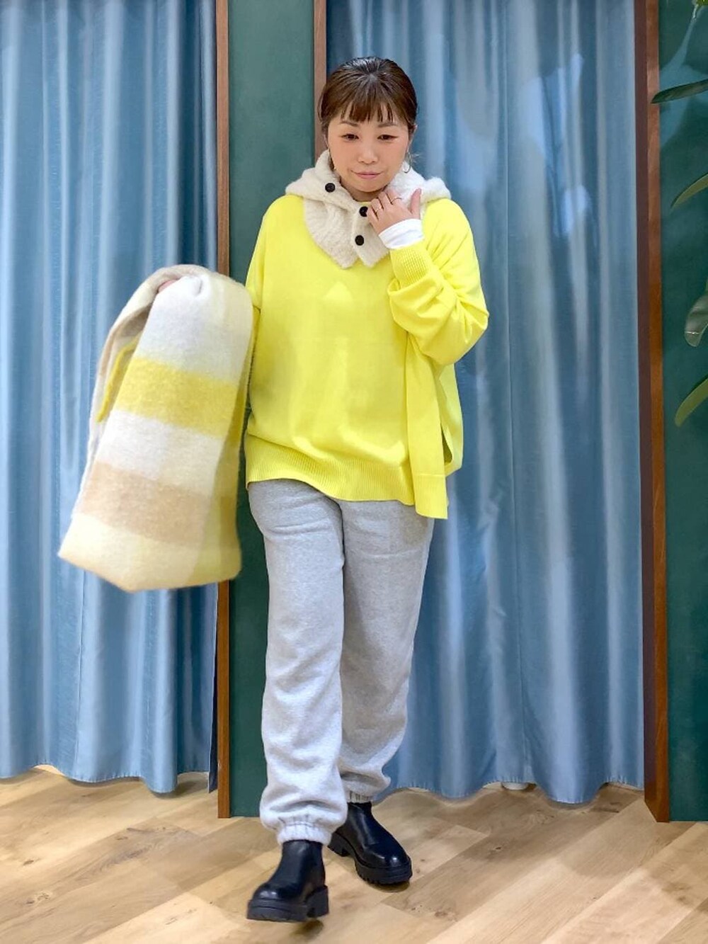 ブラック系のブーツ、ホワイト系のTシャツ/カットソー、イエロー系のニット/セーターを着用したレディースの秋コーディネートの6枚目の写真