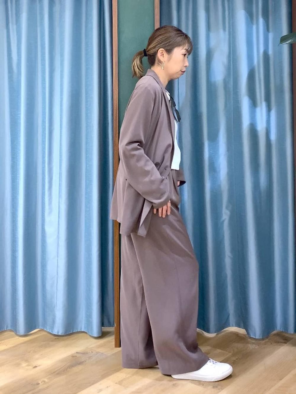 グリーン系のスラックス、ホワイト系のTシャツ/カットソー、ブラウン系のスニーカーを着用したレディースの冬コーディネートの5枚目の写真