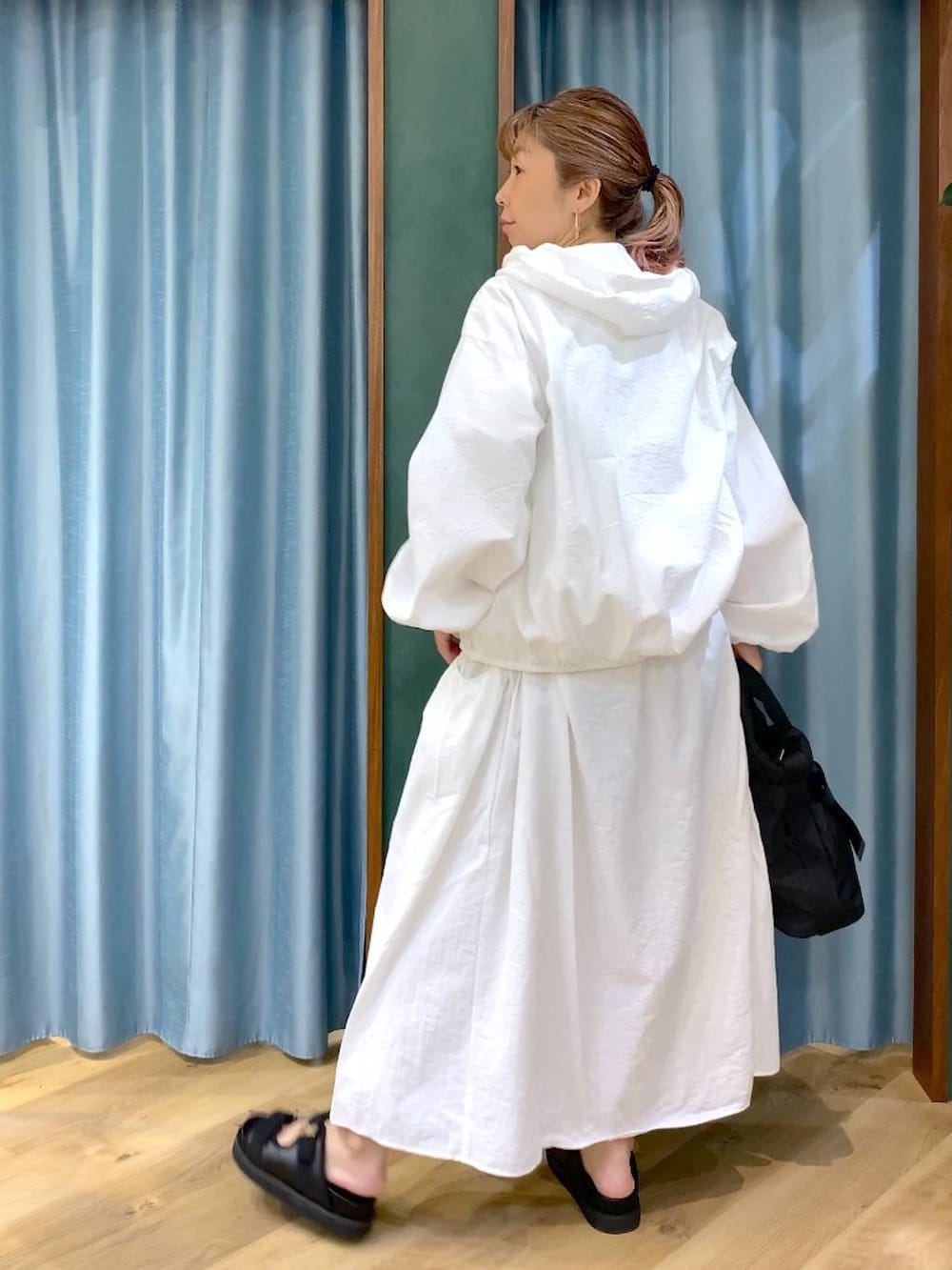 ホワイト系のスカート、ホワイト系のブルゾン、ブラック系のトートバッグを着用したレディースの春コーディネートの9枚目の写真