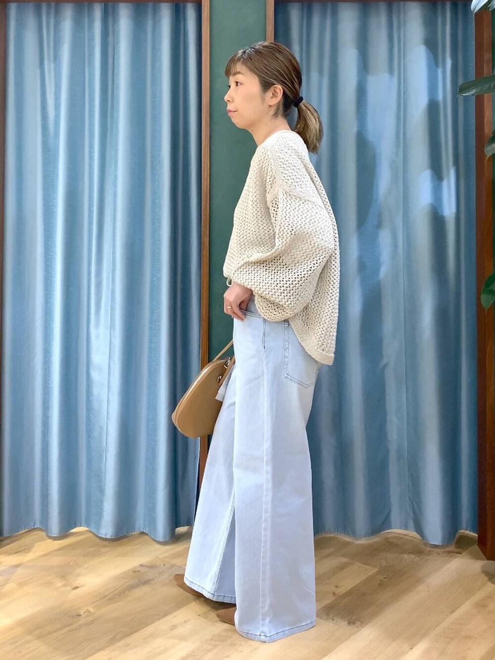 ベージュ系のニット/セーター、ブラウン系のトートバッグ、ホワイト系のTシャツ/カットソーを着用したレディースの冬コーディネートの6枚目の写真