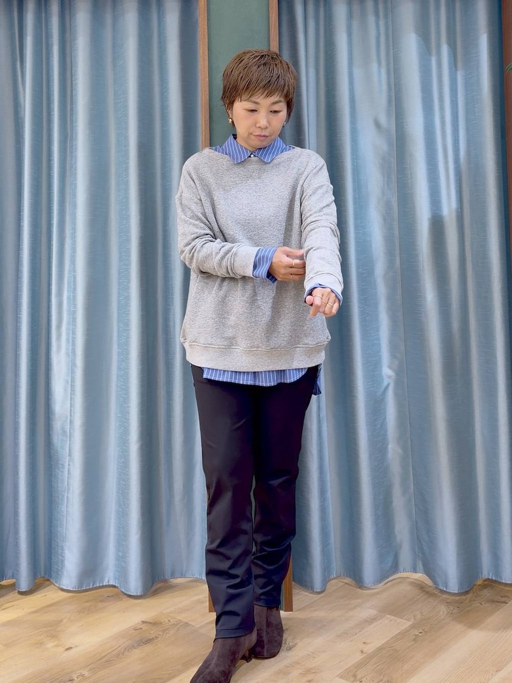 ブラック系のその他パンツ、ブラウン系のブーツ、ブルー系のシャツ/ブラウスを着用したレディースの秋コーディネートの6枚目の写真