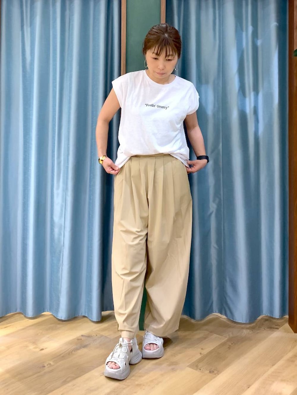 ベージュ系のその他パンツ、ホワイト系のTシャツ/カットソー、グレー系のサンダルを着用したレディースの春コーディネートの3枚目の写真