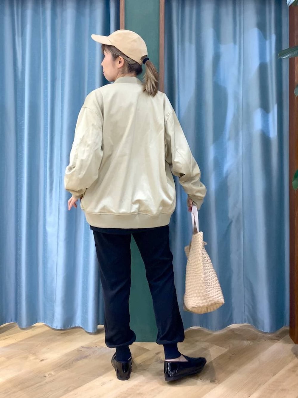 ベージュ系のMA-1、ブラック系のTシャツ/カットソー、ベージュ系のトートバッグを着用したレディースの冬コーディネートの4枚目の写真