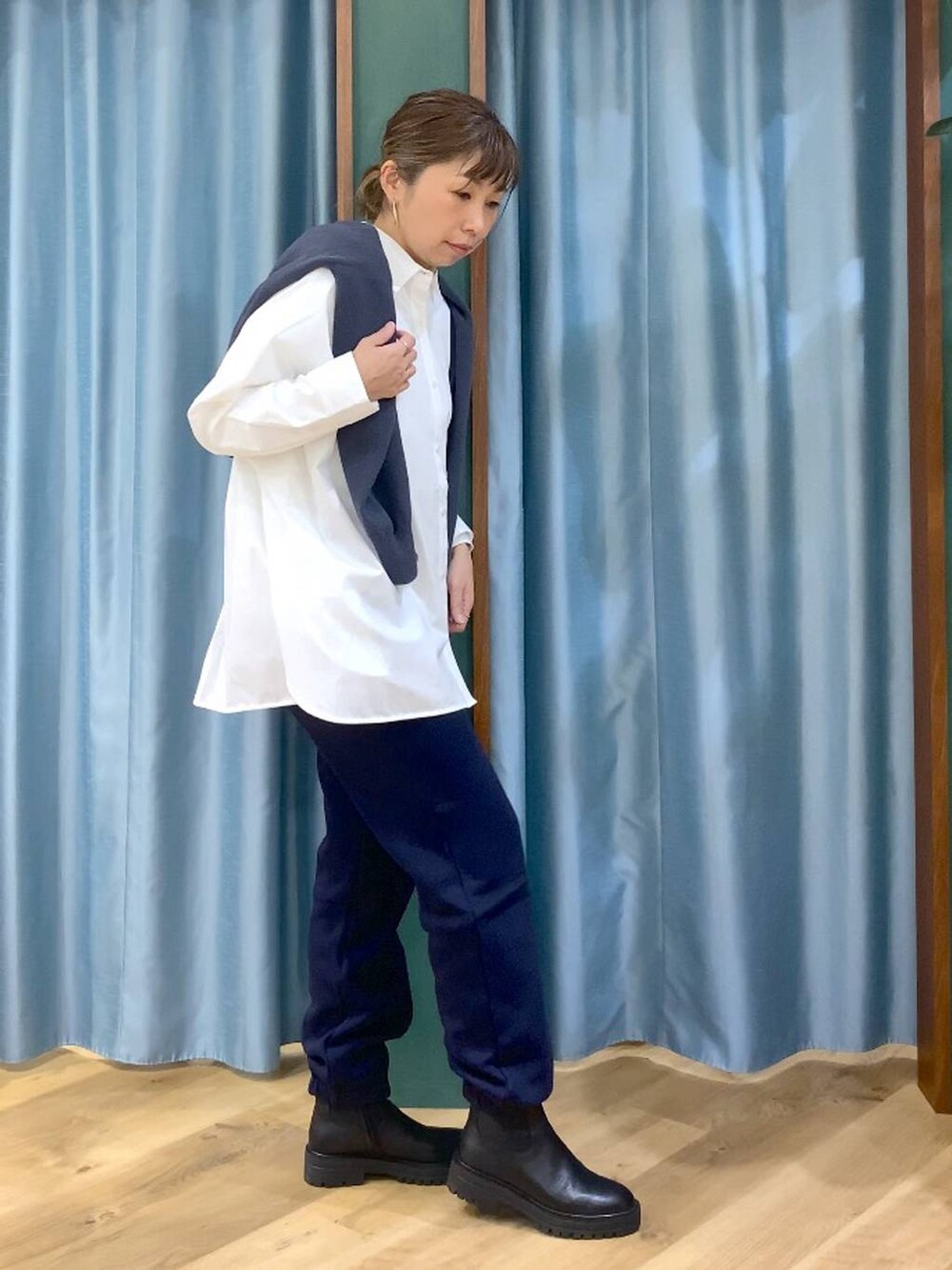 ブラック系のブーツ、ホワイト系のシャツ/ブラウス、グレー系のニット/セーターを着用したレディースの秋コーディネートの4枚目の写真