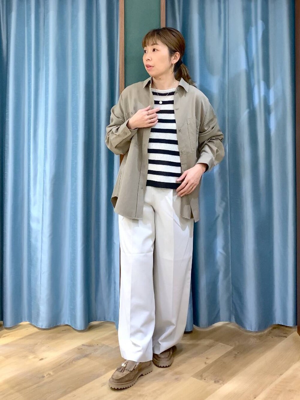 ベージュ系のローファー、グリーン系のシャツ/ブラウス、ベージュ系のニット/セーターを着用したレディースの春コーディネートの3枚目の写真