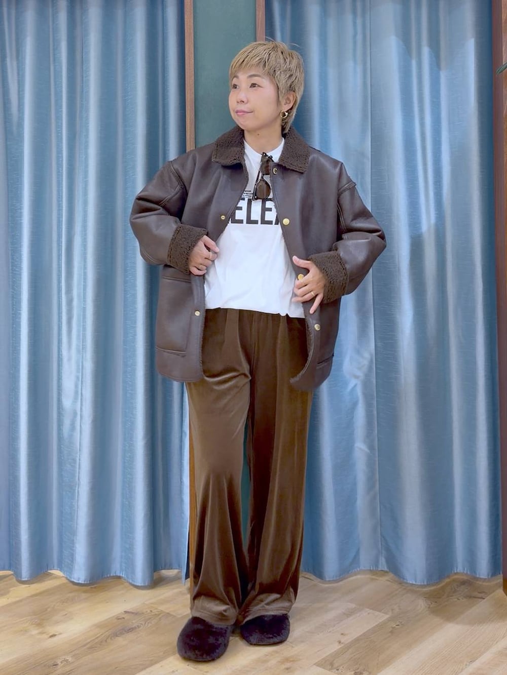 ブラウン系のムートンコート、ブラウン系のその他シューズ、ホワイト系のTシャツ/カットソーを着用したレディースの秋コーディネートの2枚目の写真