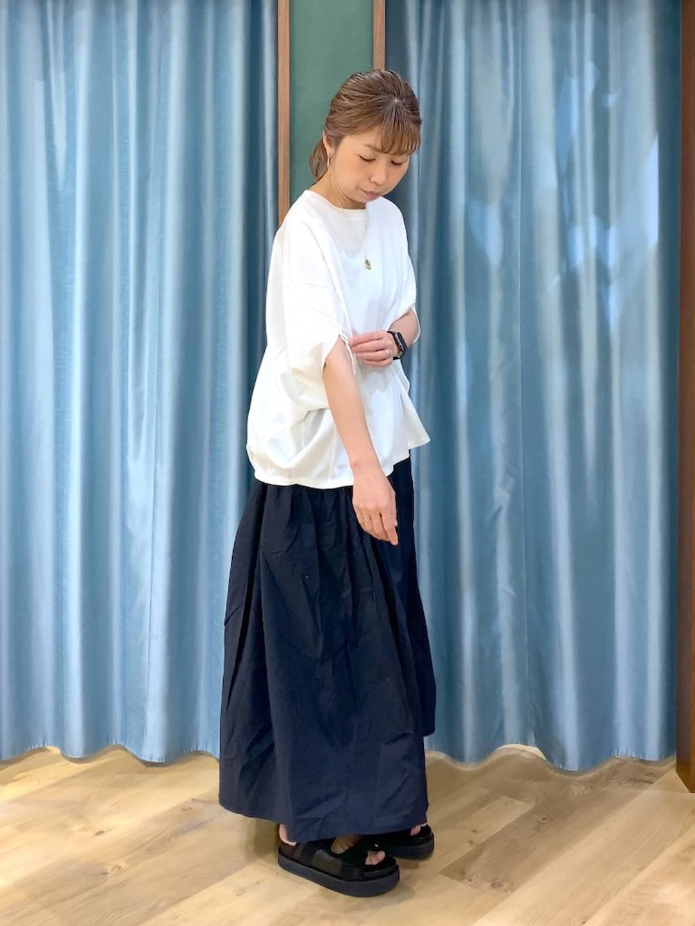 ホワイト系のTシャツ/カットソー、ブラック系のスカート、ブラック系のサンダルを着用したレディースの春コーディネートの3枚目の写真