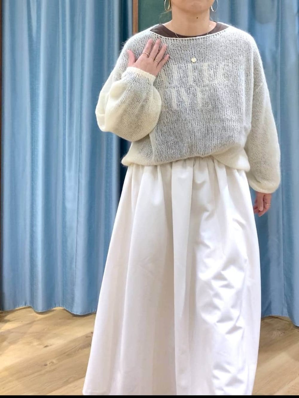 ブラック系のブーツ、ホワイト系のスカート、ホワイト系のニット/セーターを着用したレディースの冬コーディネートの9枚目の写真