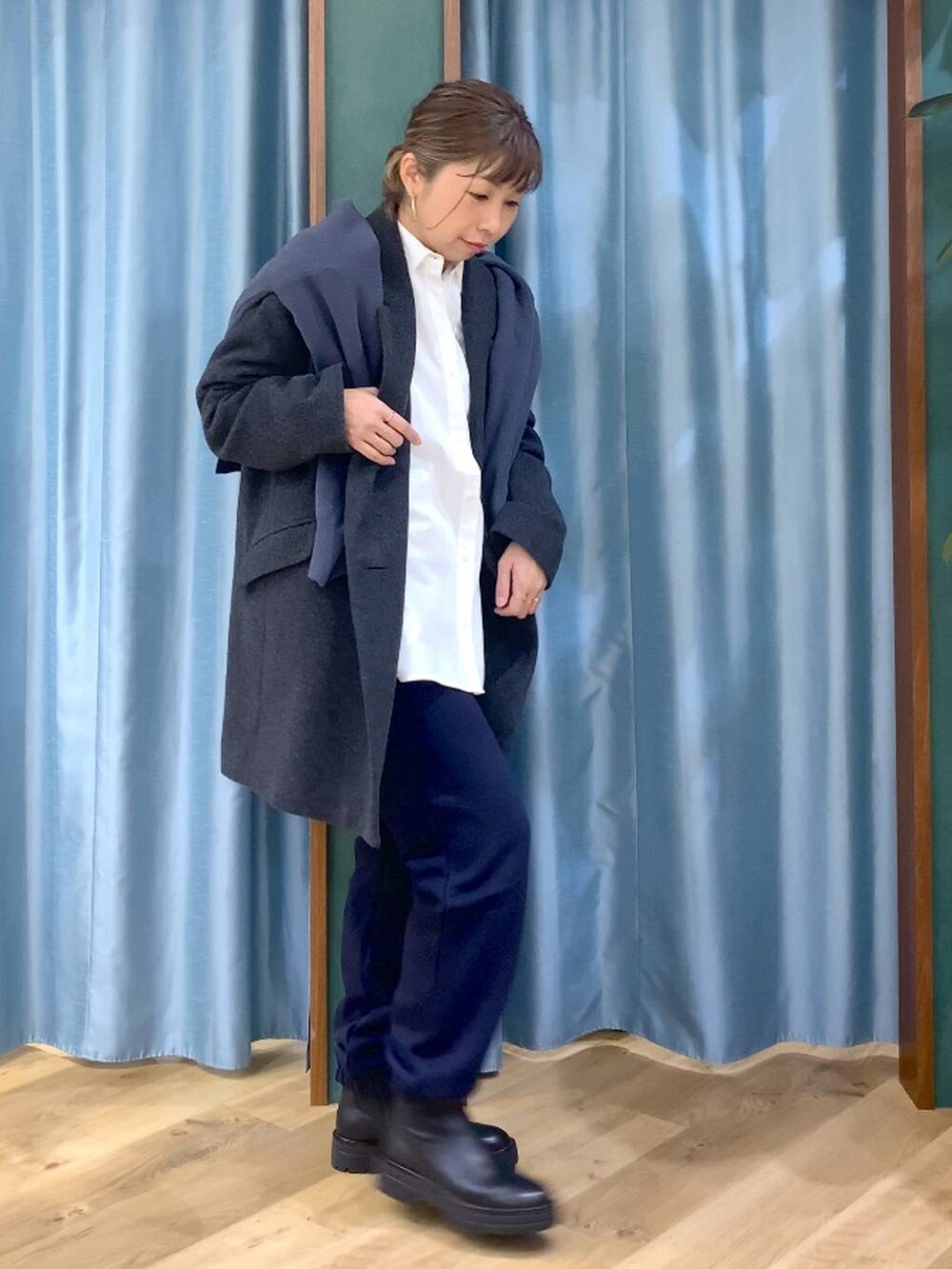 ブラック系のブーツ、ホワイト系のシャツ/ブラウス、グレー系のニット/セーターを着用したレディースの秋コーディネートの4枚目の写真