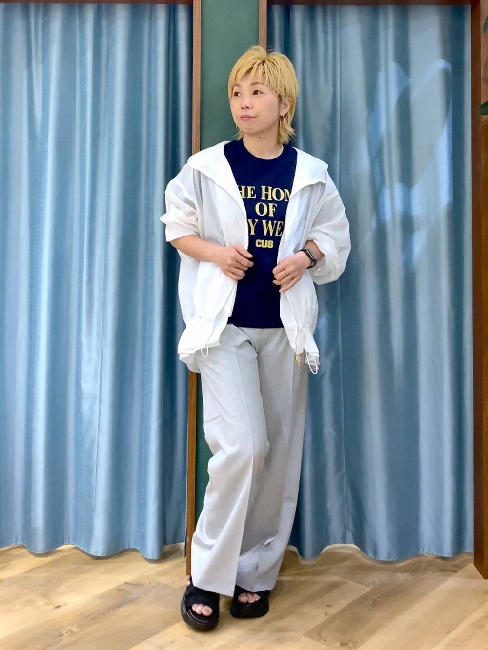 ブルー系のTシャツ/カットソー、ブラック系のサンダル、ホワイト系のブルゾンを着用したレディースの夏コーディネートの5枚目の写真