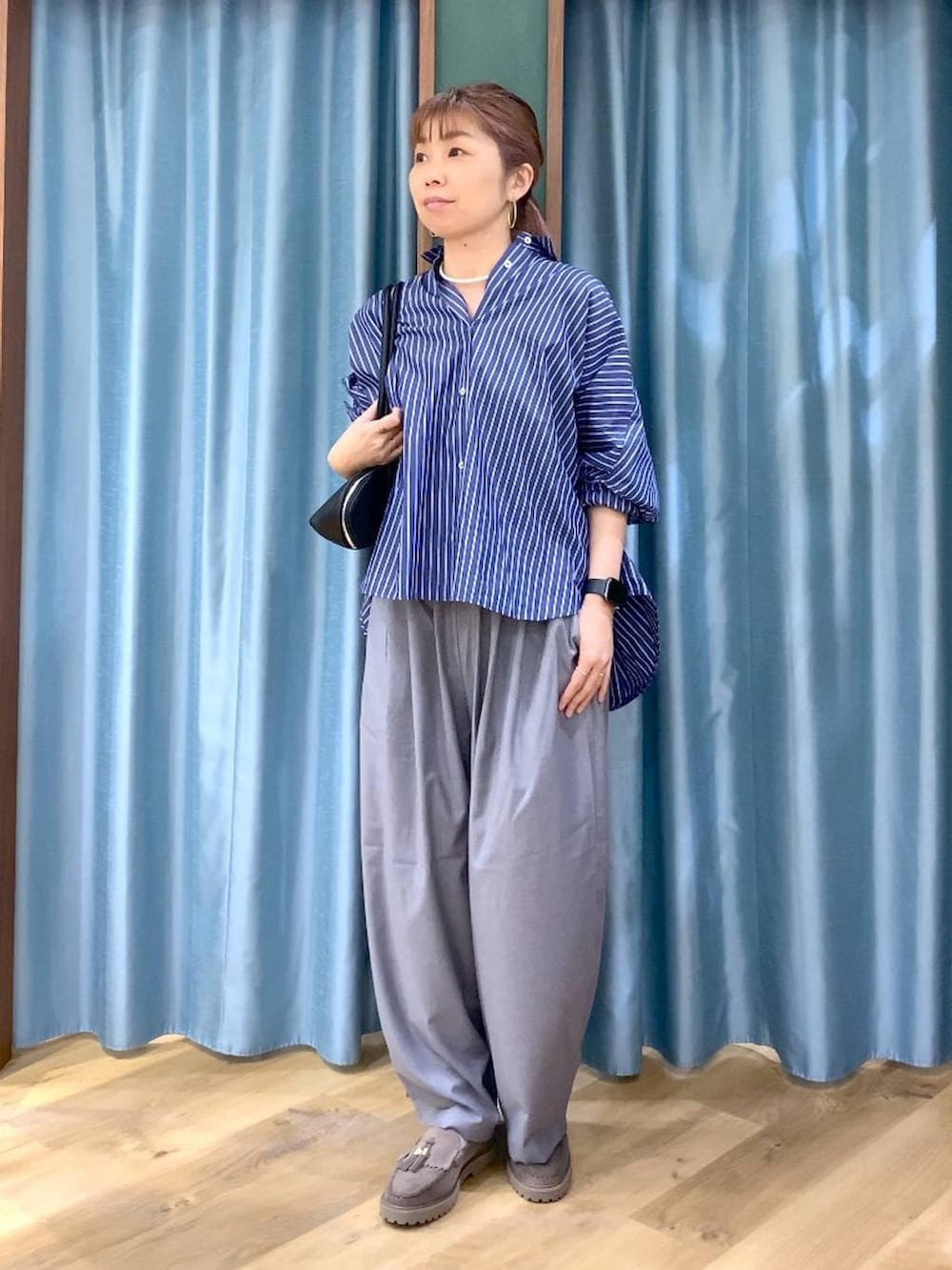 グレー系のローファー、グレー系のその他パンツ、ブルー系のシャツ/ブラウスを着用したレディースの春コーディネートの4枚目の写真