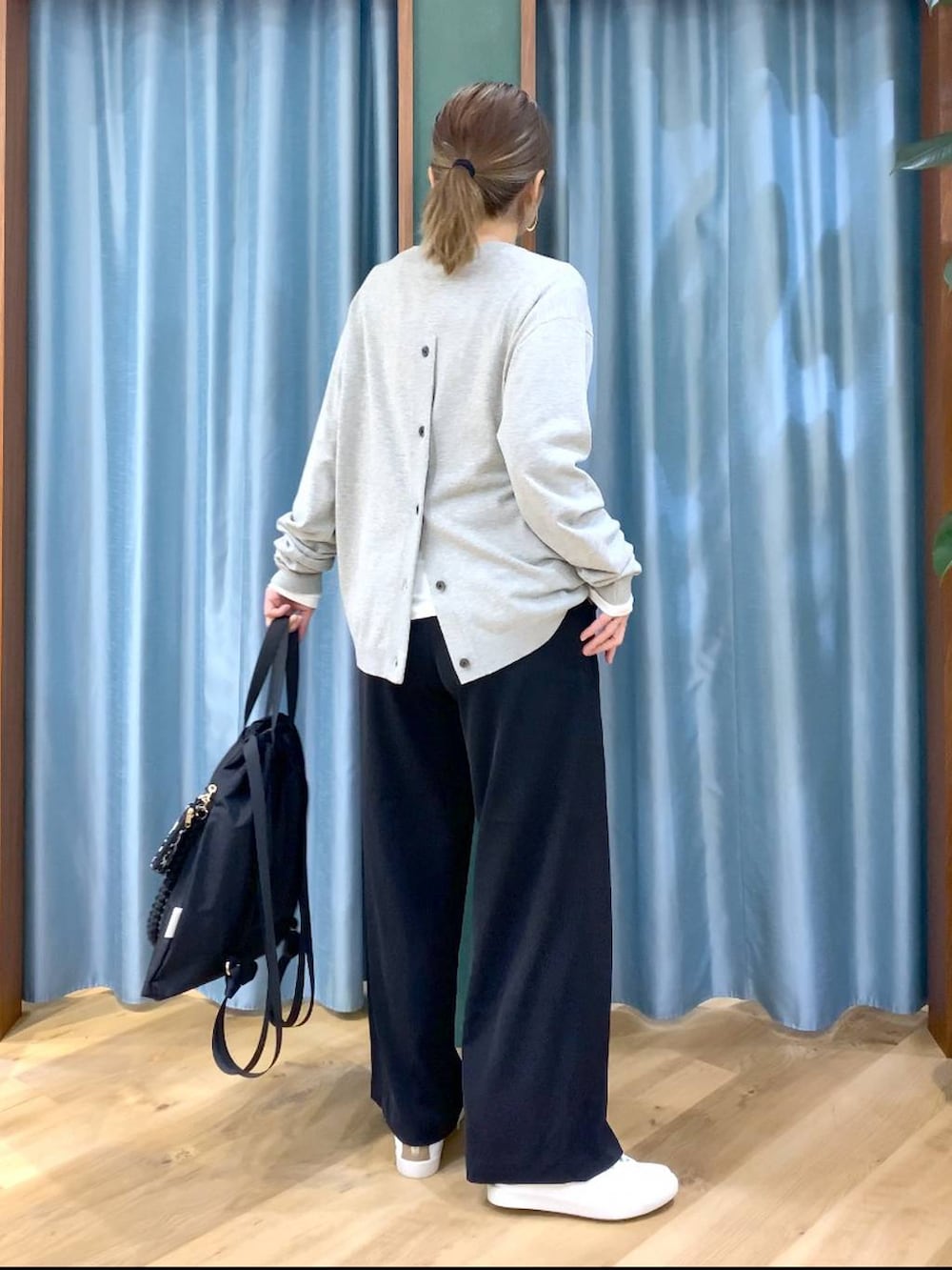 ブラック系のスラックス、ホワイト系のTシャツ/カットソー、グレー系のニット/セーターを着用したレディースの冬コーディネートの5枚目の写真