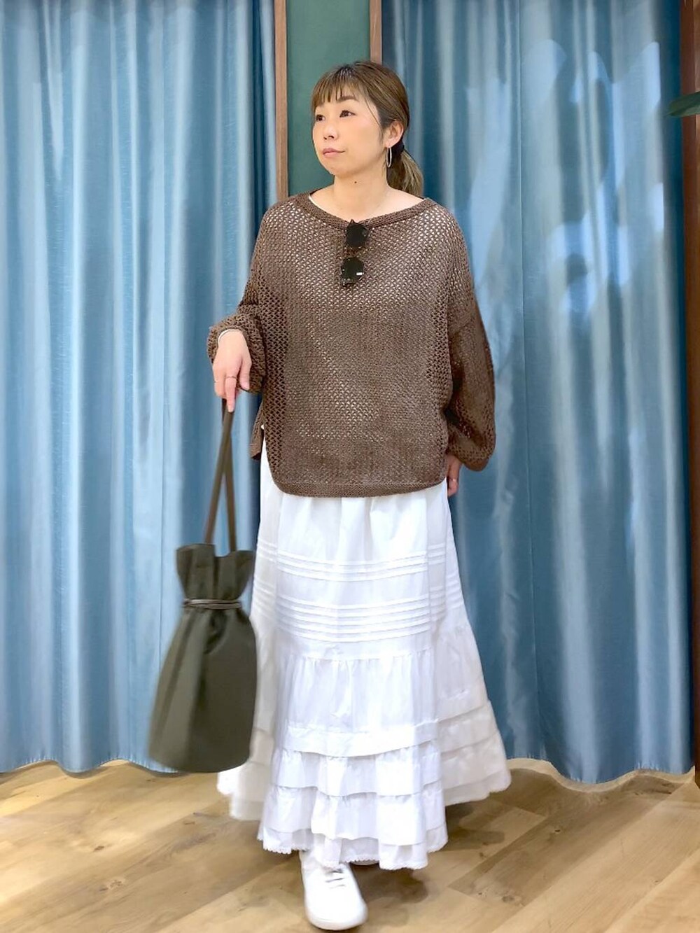 ブラウン系のスニーカー、ブラウン系のニット/セーター、ホワイト系のスカートを着用したレディースの冬コーディネートの3枚目の写真