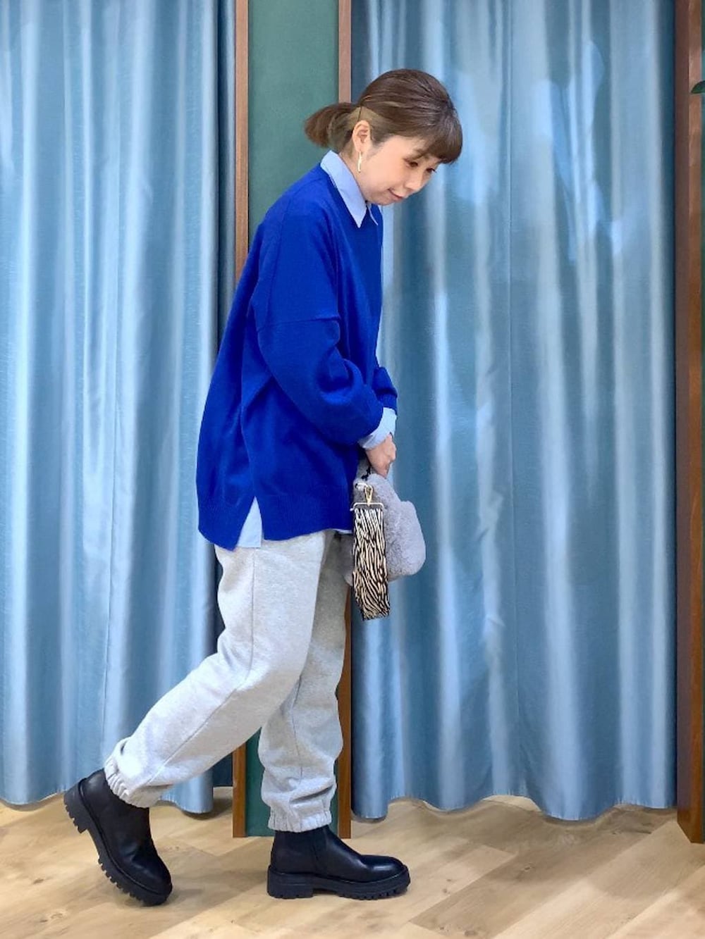 ブラック系のブーツ、ブルー系のシャツ/ブラウス、グレー系のトートバッグを着用したレディースの秋コーディネートの3枚目の写真