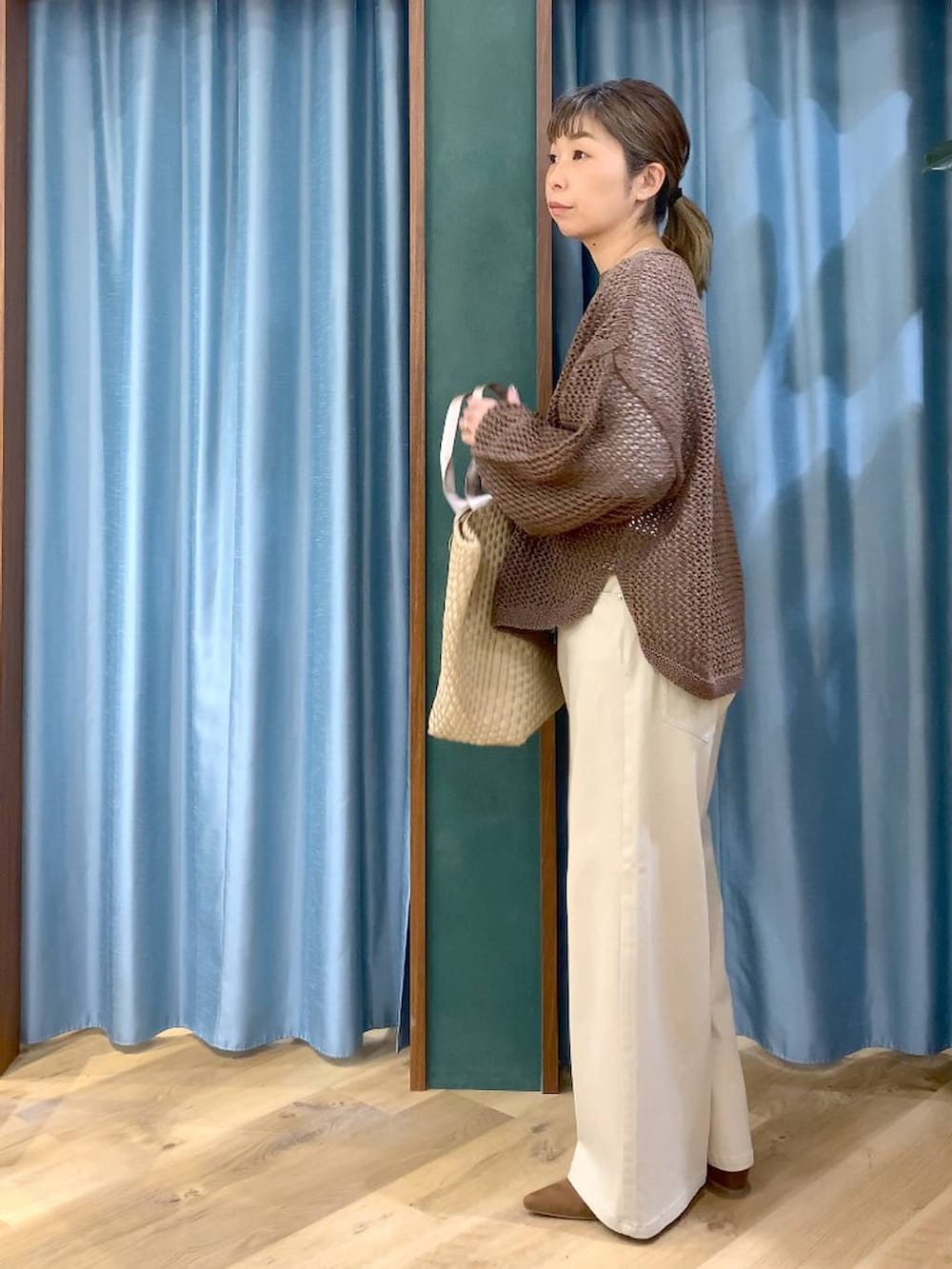 ブラウン系のニット/セーター、ホワイト系のTシャツ/カットソー、ベージュ系のデニムパンツを着用したレディースの冬コーディネートの4枚目の写真