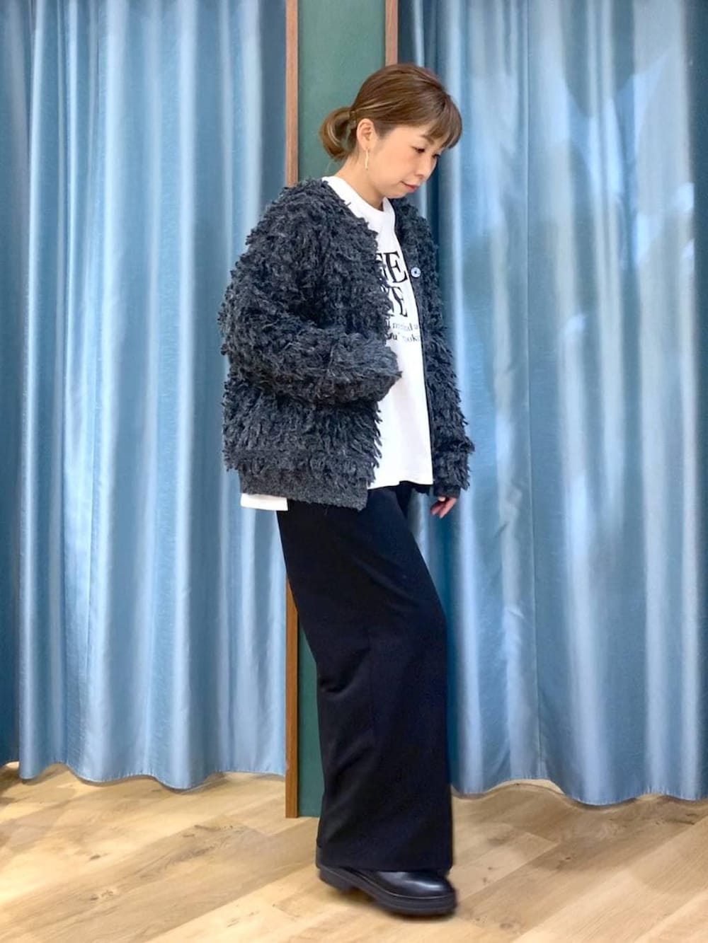 ブラック系のブーツ、ブラック系のスラックス、グレー系のカーディガン/ボレロを着用したレディースの冬コーディネートの3枚目の写真