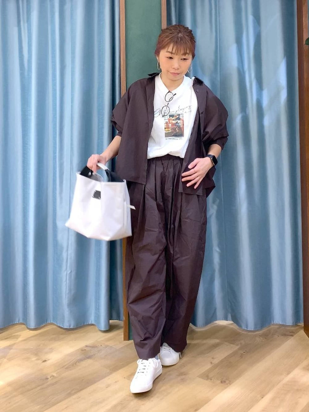 ブラウン系のその他パンツ、ブラウン系のスニーカー、ホワイト系のトートバッグを着用したレディースの春コーディネートの4枚目の写真