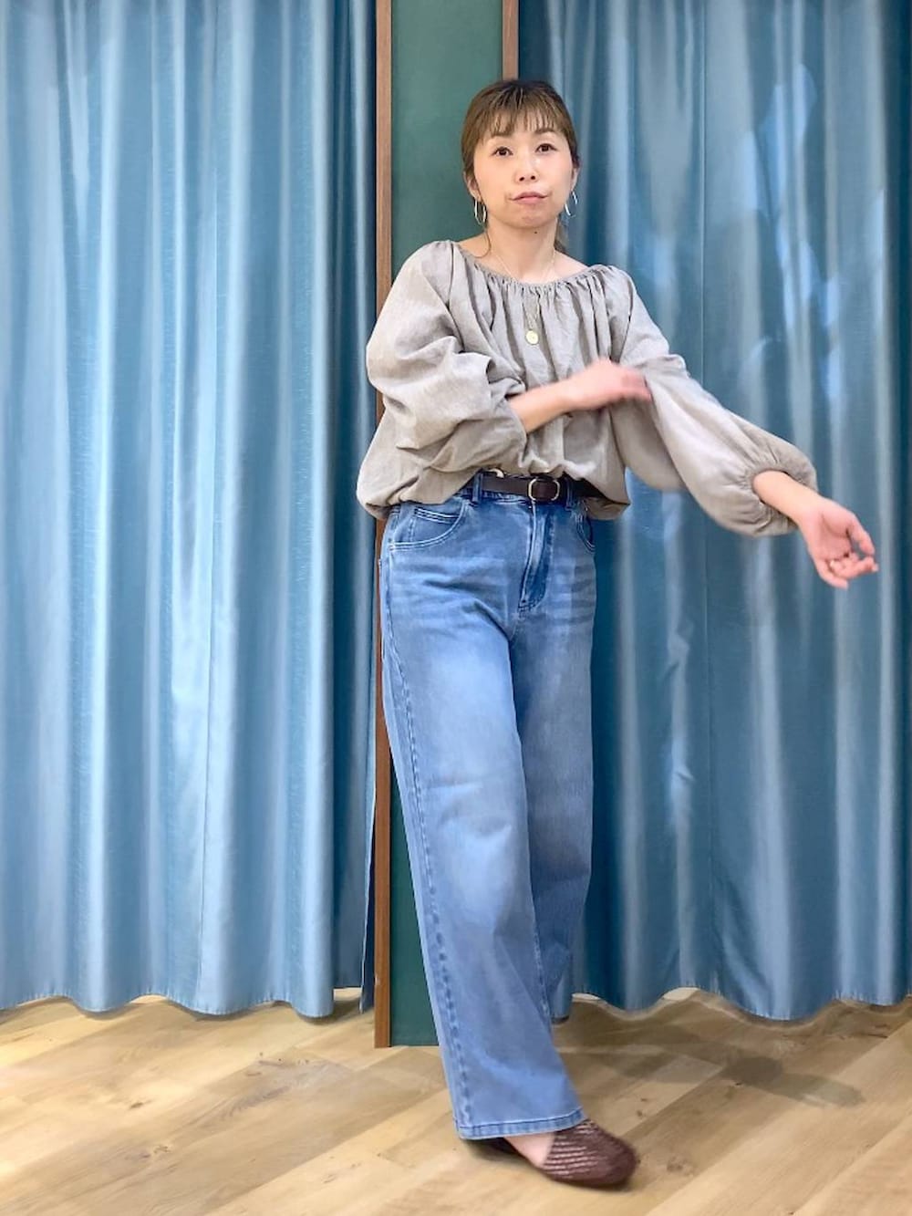 ブルー系のデニムパンツ、ベージュ系のシャツ/ブラウス、ブラウン系のスリッポンを着用したレディースの春コーディネートの5枚目の写真