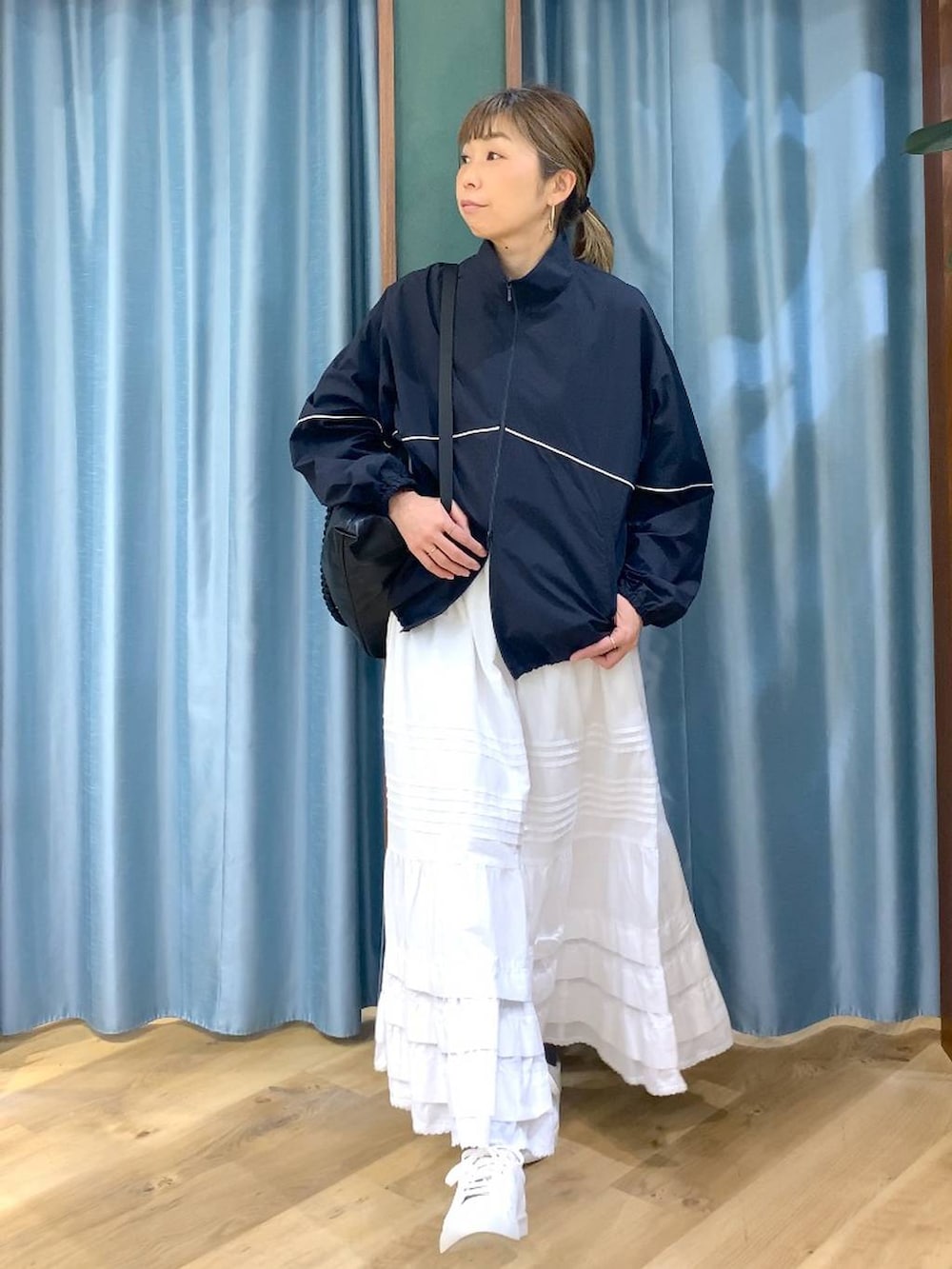 ブラック系のバックパック/リュック、ブルー系のナイロンジャケット、ブラウン系のスニーカーを着用したレディースの冬コーディネートの5枚目の写真