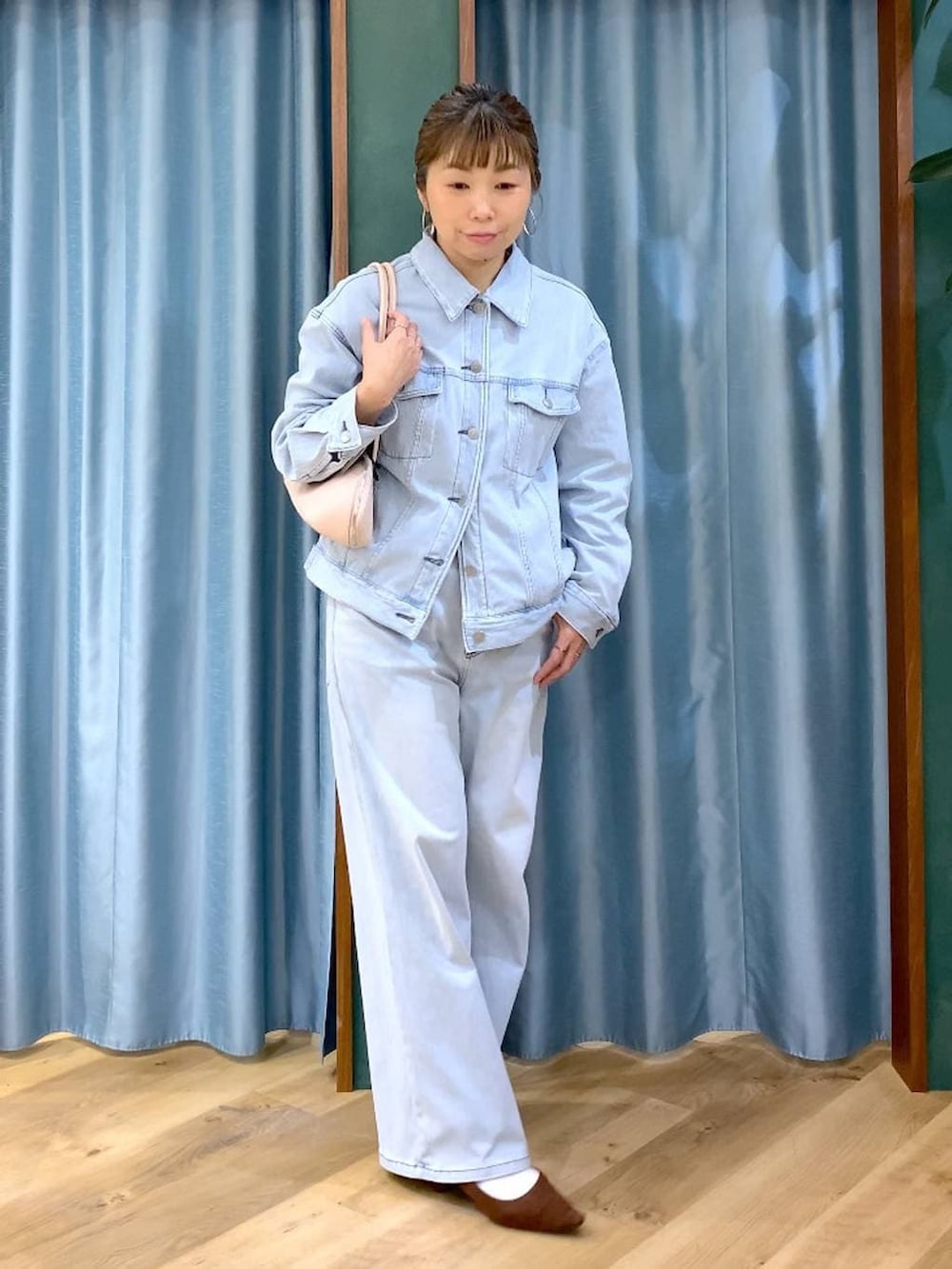 ブラウン系のパンプス、ブルー系のデニムパンツ、ブルー系のデニムジャケットを着用したレディースの春コーディネートの2枚目の写真