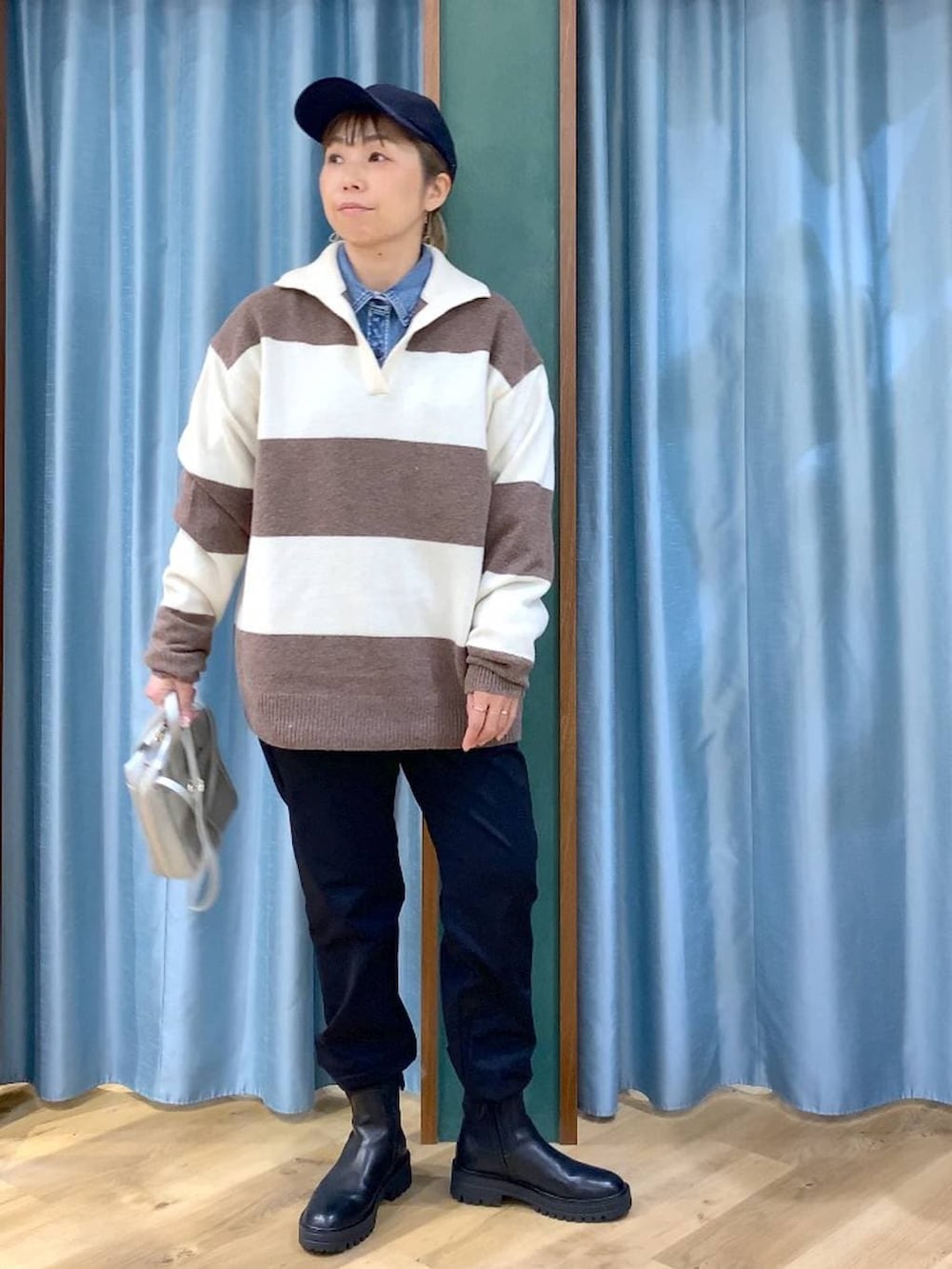 ブラック系のブーツ、ホワイト系のニット/セーター、ブルー系のシャツ/ブラウスを着用したレディースの冬コーディネートの7枚目の写真