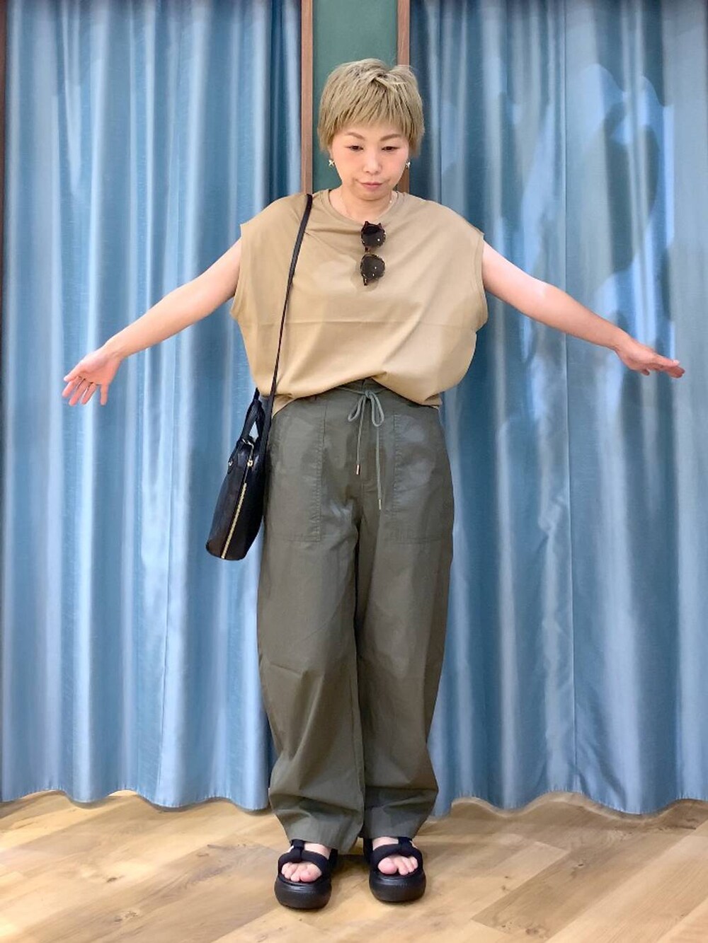 ブラック系のショルダーバッグ、グリーン系のカーゴパンツ、ブラック系のサンダルを着用したレディースの夏コーディネートの6枚目の写真
