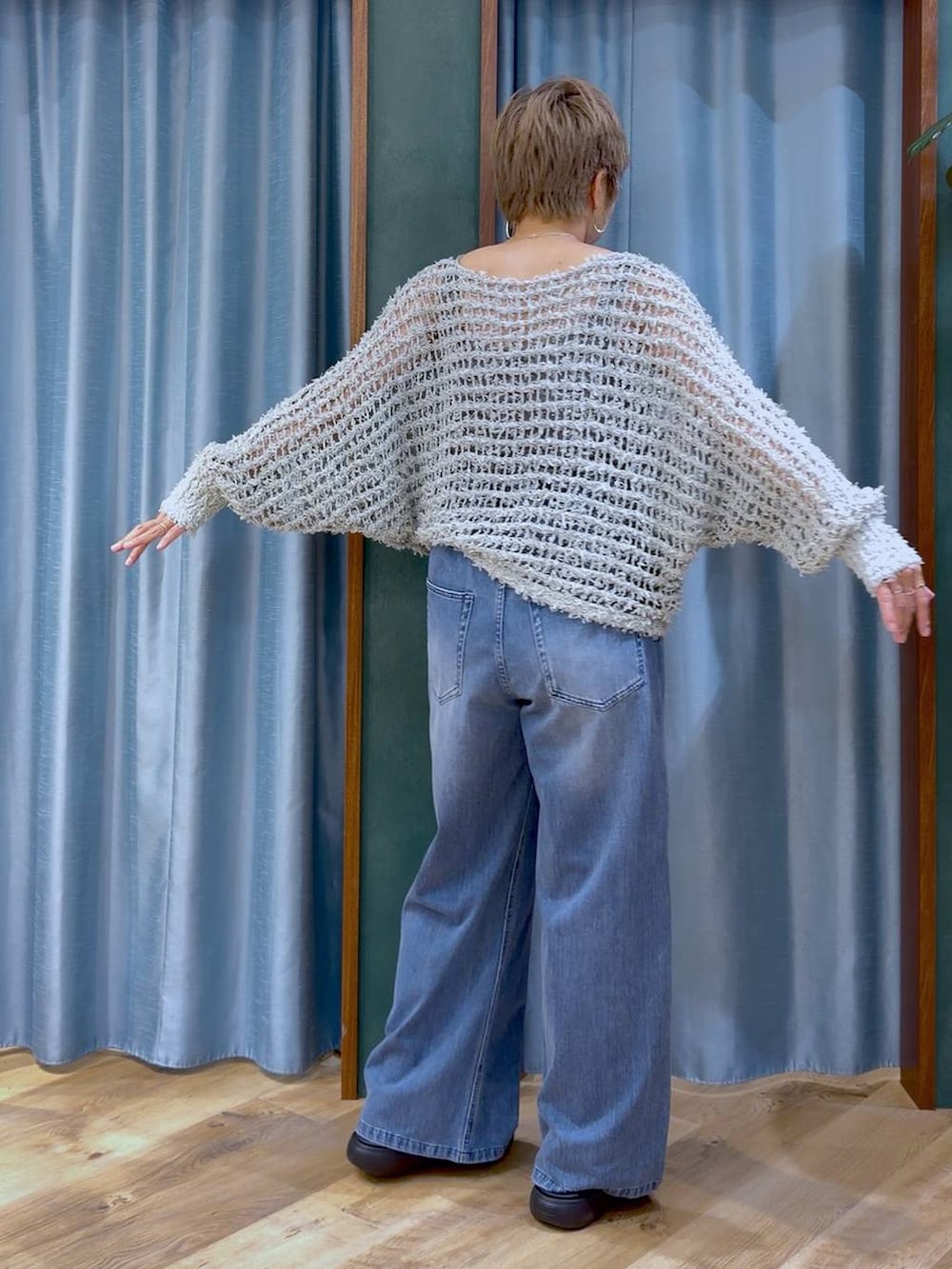 グレー系のタンクトップ、ブルー系のデニムパンツ、ブラック系のサンダルを着用したレディースの夏コーディネートの6枚目の写真