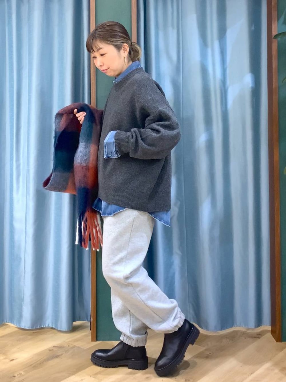 ブラック系のブーツ、ブルー系のシャツ/ブラウス、グレー系のニット/セーターを着用したレディースの秋コーディネートの2枚目の写真