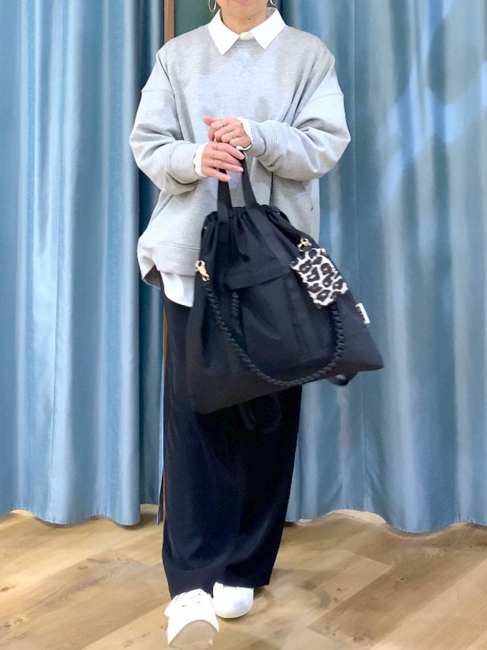 ブラック系のスラックス、グレー系のスウェット、ブラック系のバックパック/リュックを着用したレディースの冬コーディネートの7枚目の写真