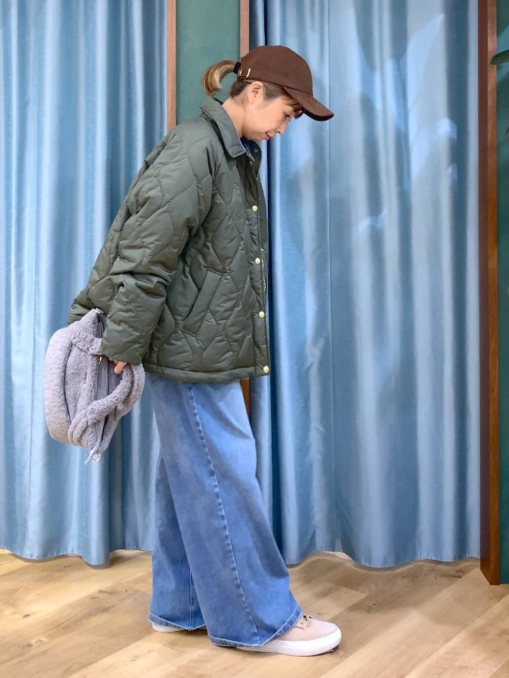 ブルー系のシャツ/ブラウス、ブルー系のデニムパンツ、グリーン系のブルゾンを着用したレディースの冬コーディネートの4枚目の写真