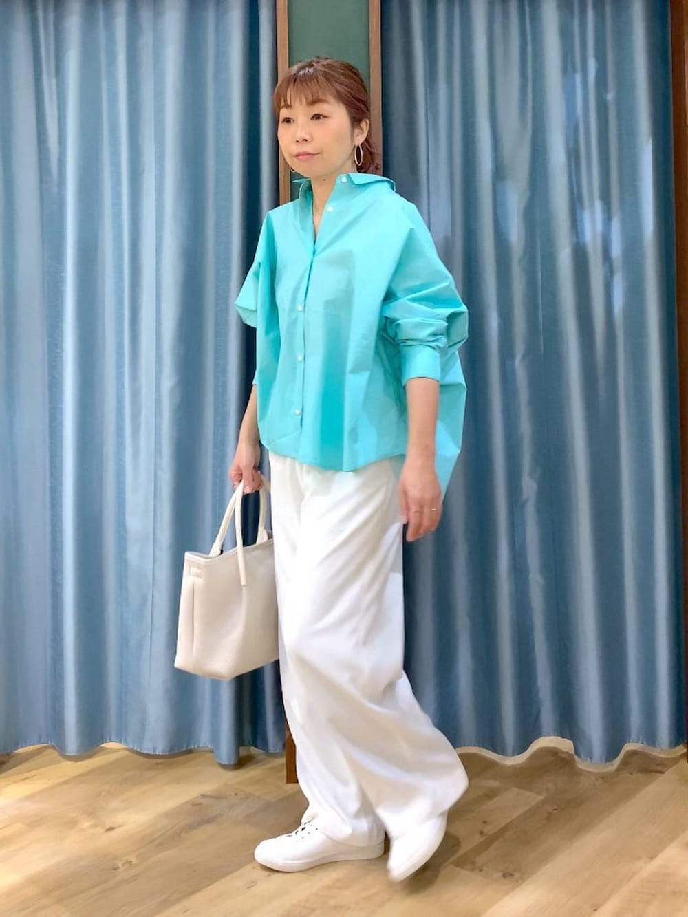 ホワイト系のスラックス、ブルー系のシャツ/ブラウス、ブラウン系のスニーカーを着用したレディースの春コーディネートの5枚目の写真