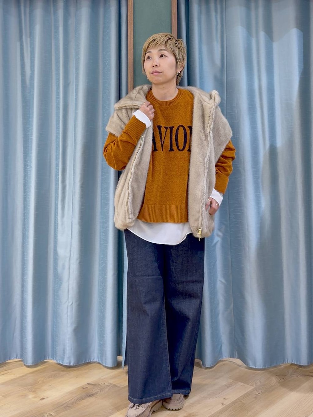 ブルー系のデニムパンツ、ベージュ系のローファー、イエロー系のニット/セーターを着用したレディースの秋コーディネートの8枚目の写真
