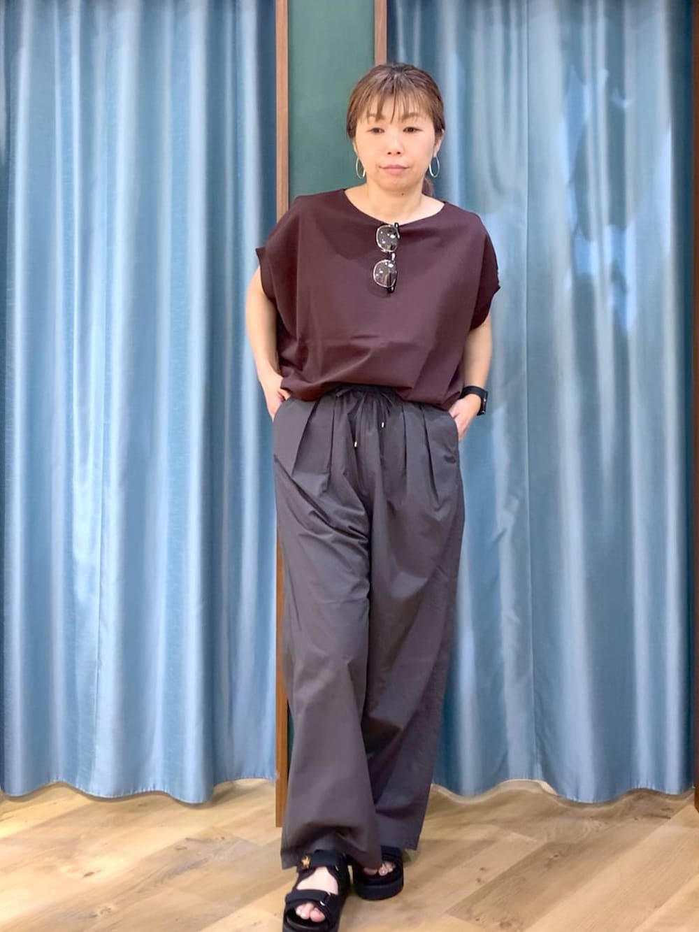 グレー系のその他パンツ、ブラウン系のTシャツ/カットソー、ブラック系のサンダルを着用したレディースの春コーディネートの2枚目の写真