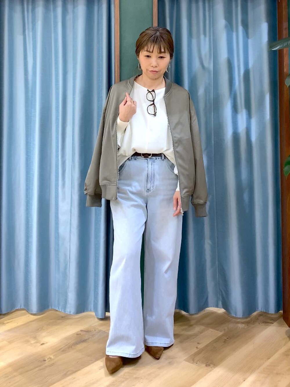 ブルー系のデニムパンツ、ホワイト系のTシャツ/カットソー、グリーン系のMA-1を着用したレディースの冬コーディネートの6枚目の写真