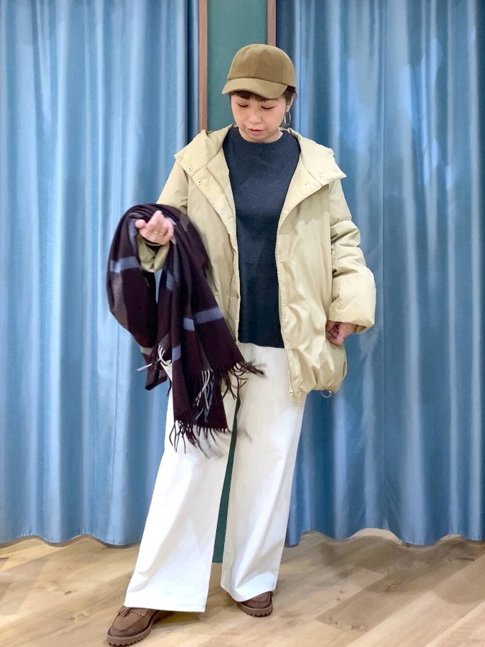 ベージュ系のダウンジャケット/コート、ブラウン系のローファー、グレー系のニット/セーターを着用したレディースの秋コーディネートの5枚目の写真