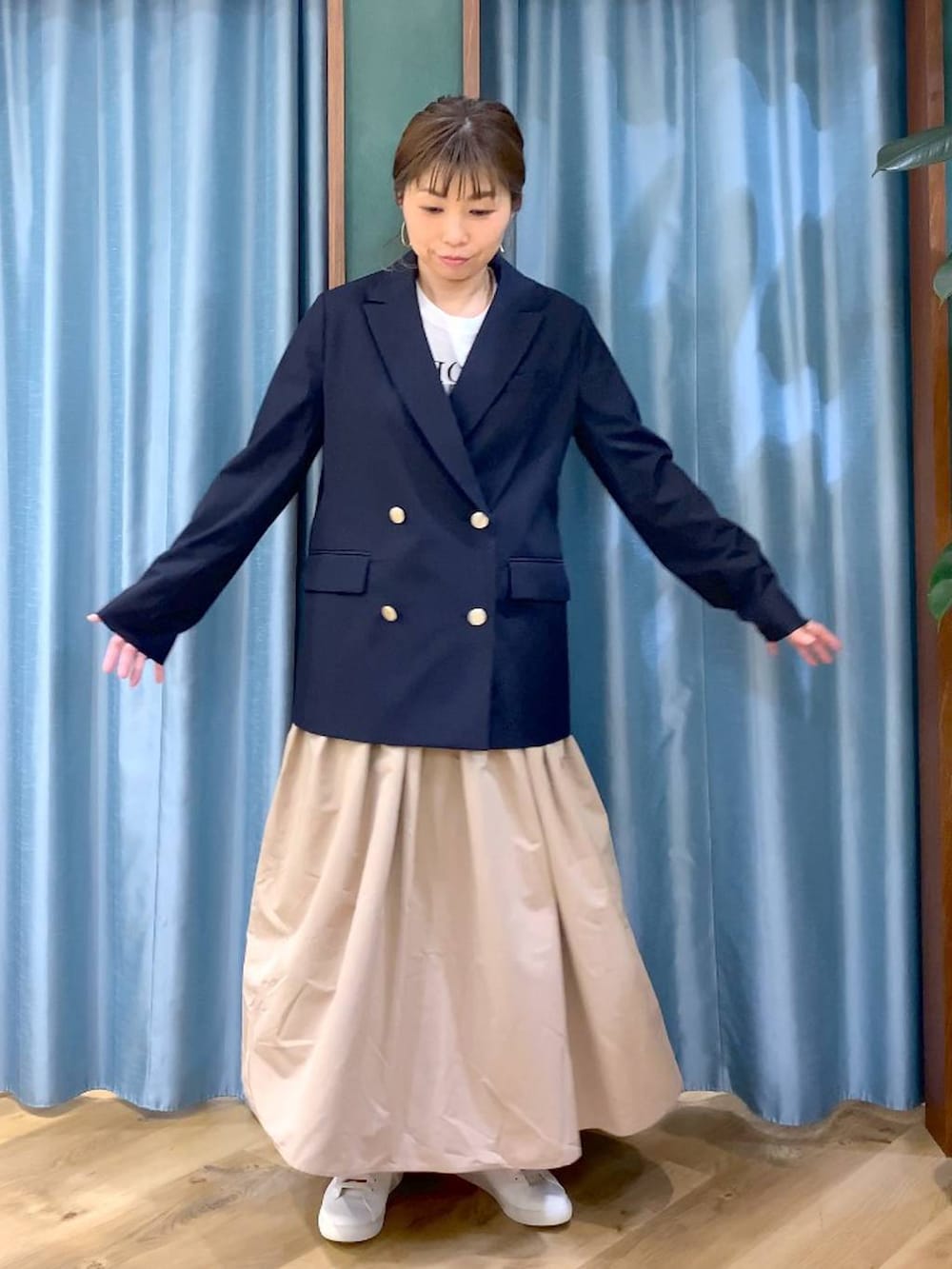 ベージュ系のスカート、ブルー系のテーラードジャケット、ベージュ系のトートバッグを着用したレディースの冬コーディネートの5枚目の写真