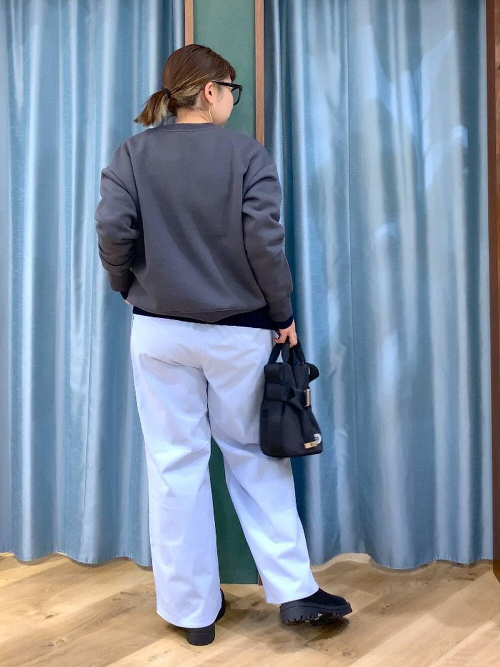 ブラック系のブーツ、ブラック系のショルダーバッグ、ブルー系のニット/セーターを着用したレディースの秋コーディネートの4枚目の写真