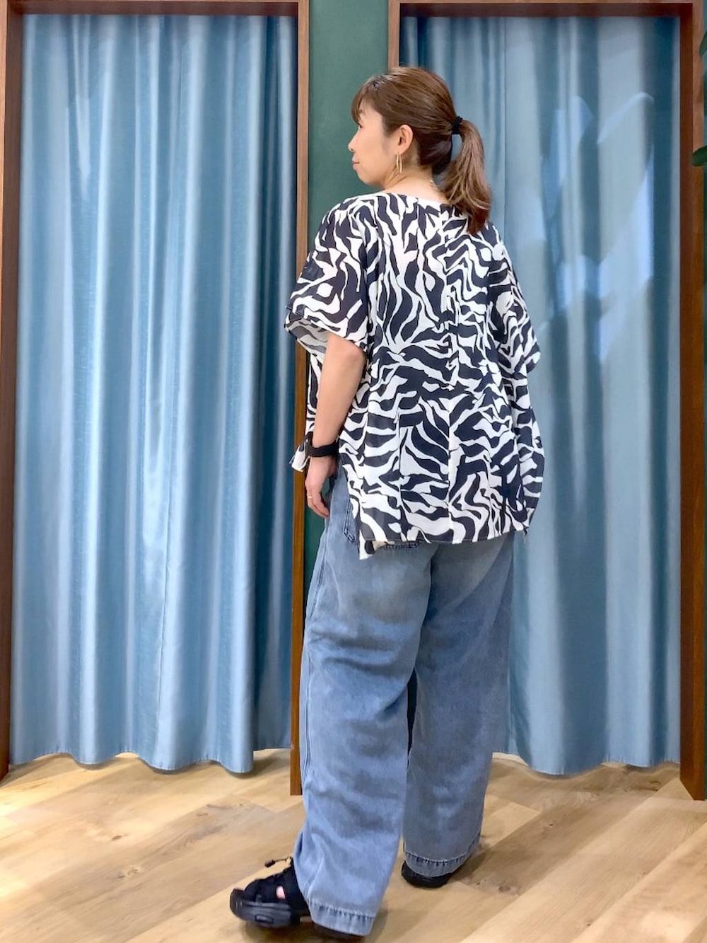 ブルー系のデニムパンツ、ブラック系のシャツ/ブラウス、ブラック系のサンダルを着用したレディースの春コーディネートの4枚目の写真