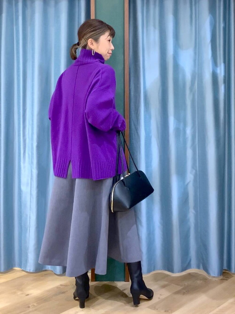 ブラック系のトートバッグ、グレー系のスカート、ブラック系のブーツを着用したレディースの秋コーディネートの6枚目の写真