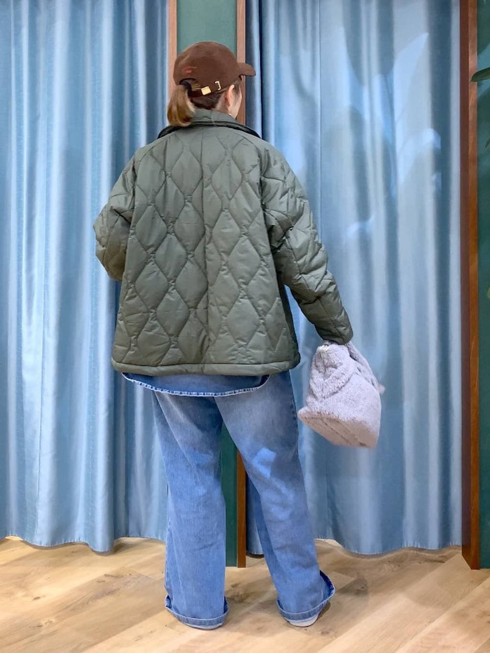 ブルー系のシャツ/ブラウス、ブルー系のデニムパンツ、グリーン系のブルゾンを着用したレディースの冬コーディネートの6枚目の写真