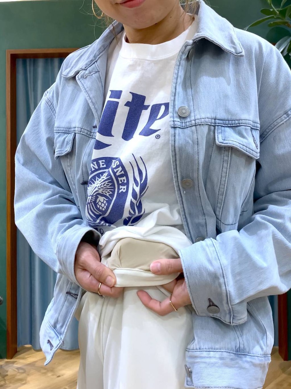 ホワイト系のスラックス、ブルー系のデニムジャケット、ホワイト系のTシャツ/カットソーを着用したレディースの冬コーディネートの4枚目の写真