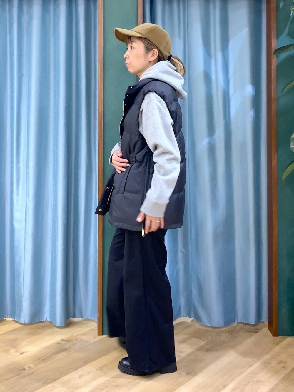 ブラック系のブーツ、グレー系のパーカー、ブラック系のダウンベストを着用したレディースの冬コーディネートの3枚目の写真