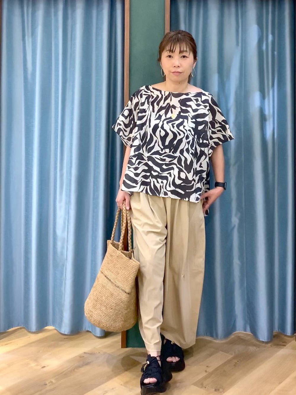 ブラック系のシャツ/ブラウス、ベージュ系のその他パンツ、ブラック系のサンダルを着用したレディースの春コーディネートの3枚目の写真