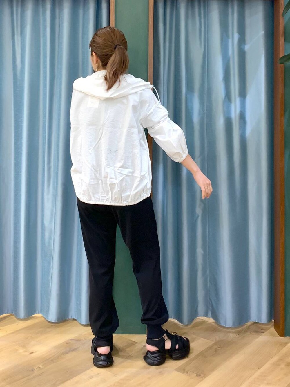 ホワイト系のブルゾン、ベージュ系のTシャツ/カットソー、ブラック系のサンダルを着用したレディースの春コーディネートの6枚目の写真