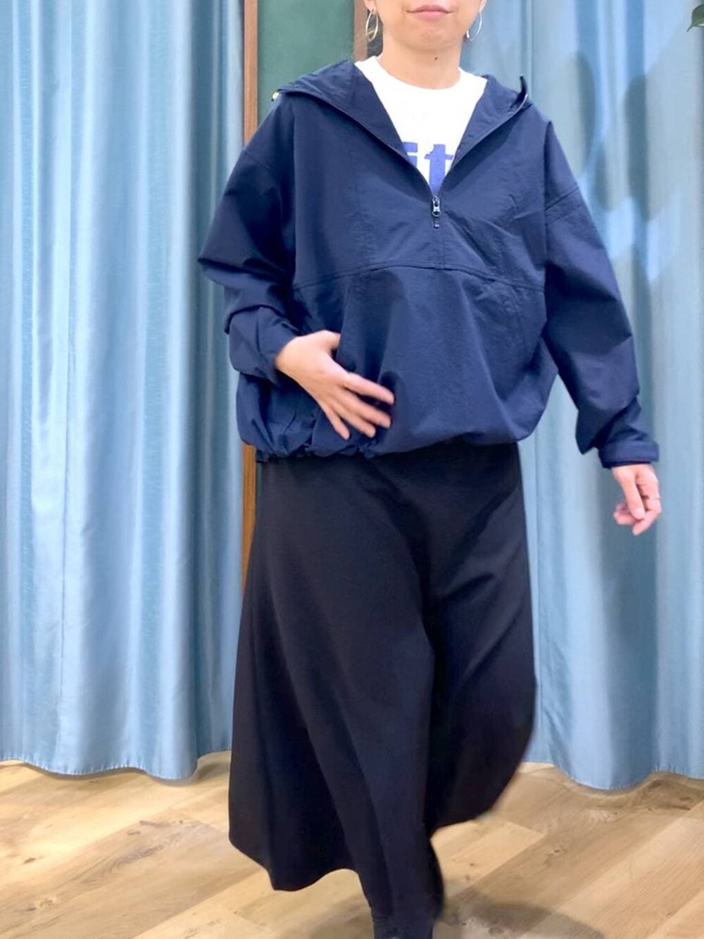 ブラック系のブーツ、ブラック系のスカート、ブルー系のナイロンジャケットを着用したレディースの冬コーディネートの7枚目の写真