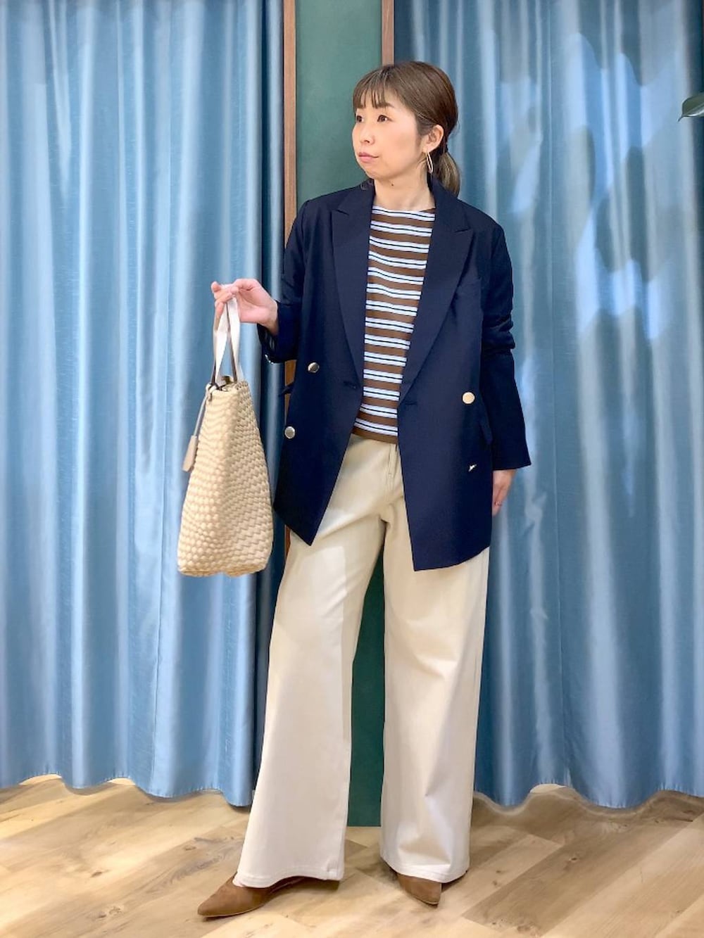 ブラウン系のTシャツ/カットソー、ベージュ系のデニムパンツ、ブルー系のテーラードジャケットを着用したレディースの冬コーディネートの6枚目の写真