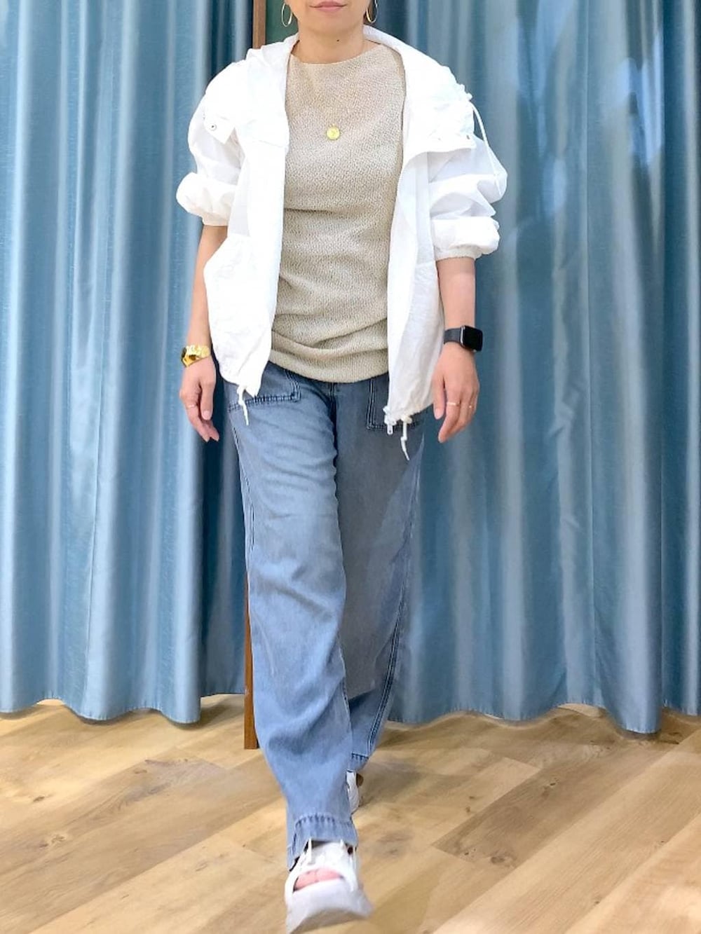 ブルー系のデニムパンツ、ホワイト系のブルゾン、グレー系のサンダルを着用したレディースの春コーディネートの6枚目の写真