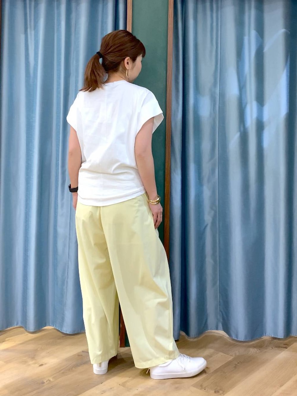 ホワイト系のTシャツ/カットソー、イエロー系のその他パンツ、ホワイト系のスニーカーを着用したレディースの春コーディネートの5枚目の写真